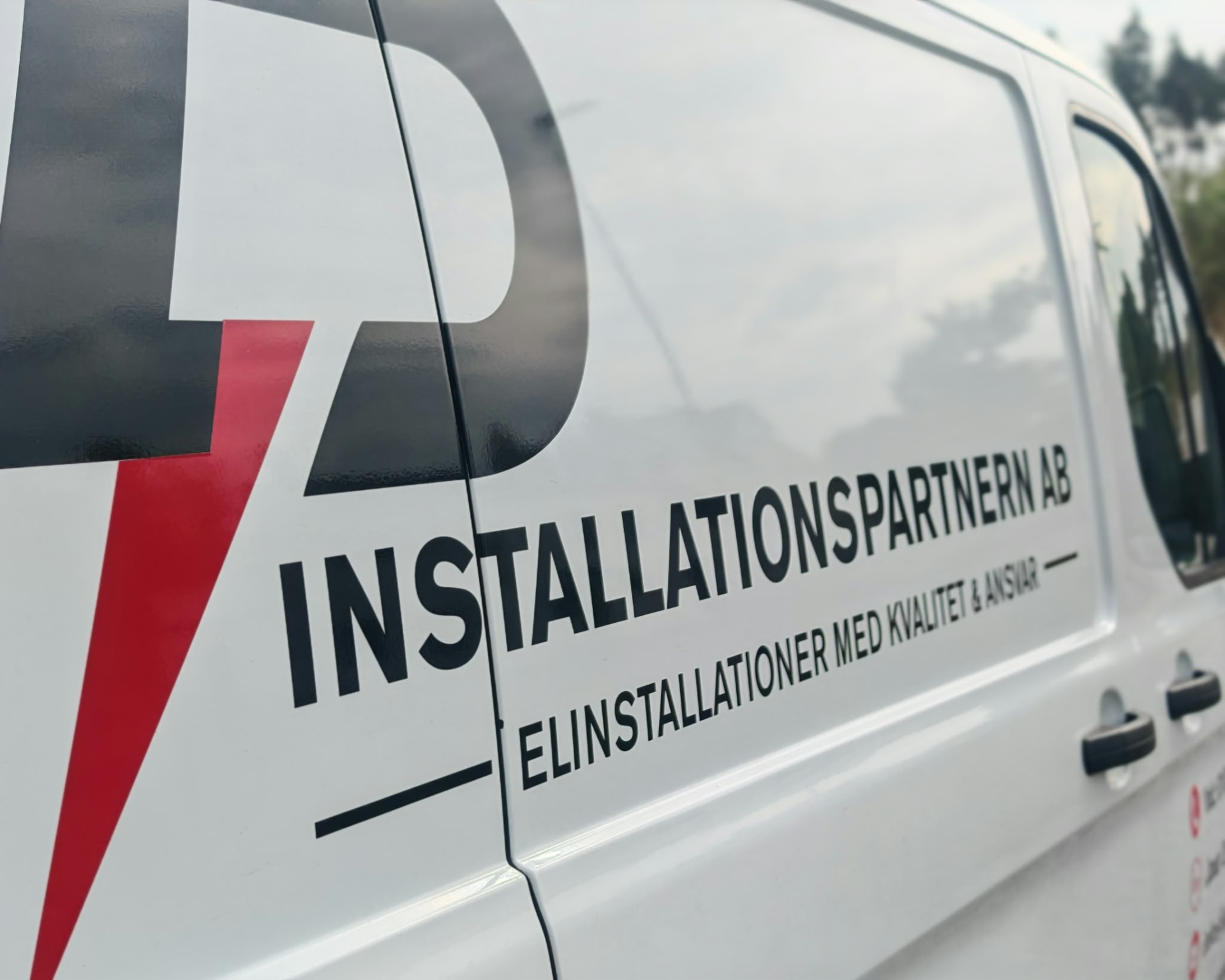 Närbild på InstallationsPartnern AB:s logotyp på en av firmans servicebilar